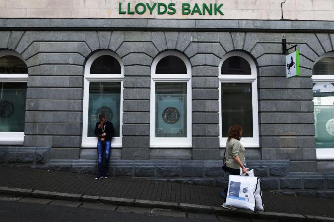 Uma mulher anda após o banco britânico, Lloyds Bank, na ilha de Guernsey